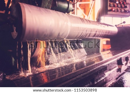 Grinding of the large shaft on the machine, finishing of the large round part, wide-angle toned photo