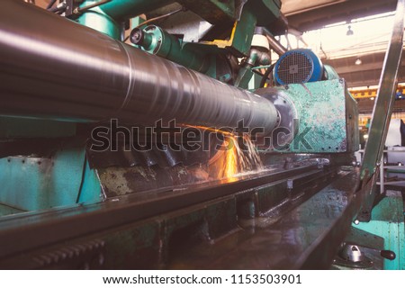 Grinding of the large shaft on the machine, finishing of the large round part, wide-angle toned photo