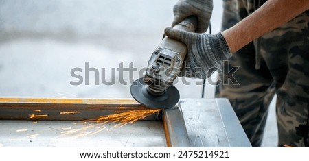 Grinding machine at work. Sparks fly from under the grinders, men's work. Dark background with copy space.
