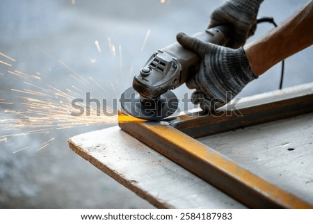 Grinding machine at work. Sparks fly from under the grinders, men's work. Dark background with copy space.