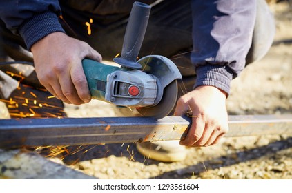 Grinding Metal! Craftman Cutting A Metal Tube With Unprotected Hands With A Hand Grinding Tool. Sparks And Flames Produced By The Cutting Process. Labor Accident Risk.