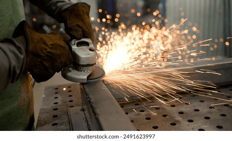 Grinding a steel structure with an electric wheel at a factory. Door industry factory. Sparks from the grinding wheel. Grinding a metal door in production. - Powered by Shutterstock