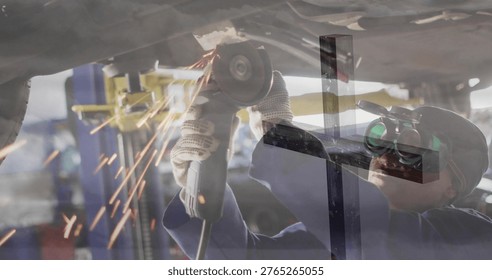 Grinding tech using angle grinder under car in garage in coverall cap goggles gloves, sparks flying. Mechanic, woman, workshop, industrial, eyeprotection, lift, tools