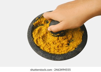 Grinding yellow spices with a stone or the process of making opor base spices manually. - Powered by Shutterstock