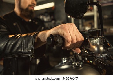 The Grip. Cropped Closeup Of A Biker Hand On Motorcycle Handlebars Man Sitting On His Motorbike At The Workshop Hand Close Up Holding Handle Bars Riding Concept