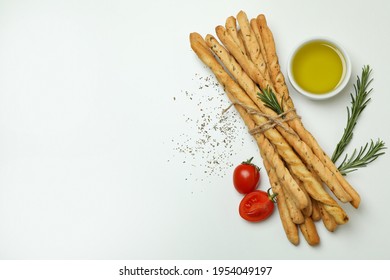 Grissini breadsticks with spices on white background