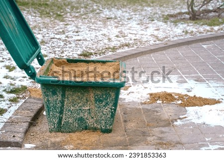 Grit bin for treatment paving slabs from snow and ice. Sand box for improve traction on snowy, icy sidewalk, road maintenance in winter season. Plastic grit container, green street furniture