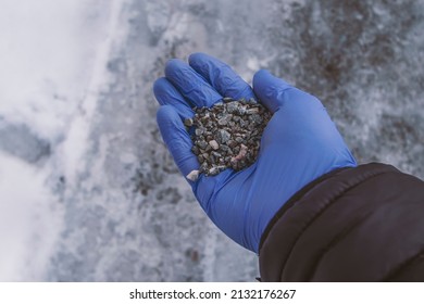 Gritting A Slippery Street With Granite In Winter, POV View Of A Worker's Hand In Blue Glove