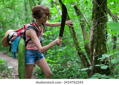 Gritty Survivalist Female Hiker Cleaning a Parasite Plant from a Tree on a Footpath in Woods - Powered by Shutterstock