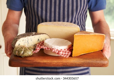 Grocer Holding Board With Selection Of Luxury Cheeses - Powered by Shutterstock