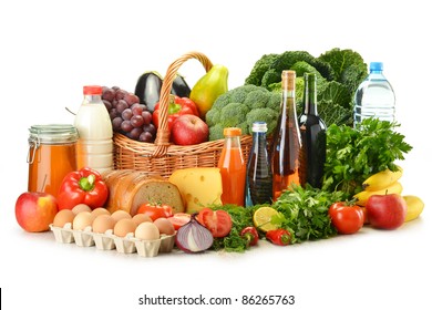Groceries in wicker basket including vegetables, fruits, bakery and dairy products and wine isolated on white - Powered by Shutterstock