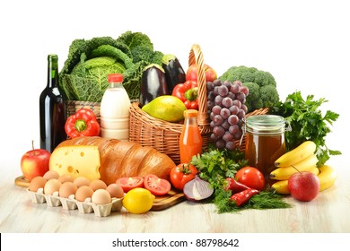 Groceries in wicker basket including vegetables, fruits, bakery and dairy products and wine isolated on white - Shutterstock ID 88798642