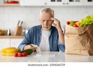 Grocery Expenses. Upset Senior Man In Kitchen Checking Bill After Food Shopping, Confused Elderly Gentleman Sitting At Table And Looking At Receipt, Suffering Financial Crisis And Poverty, Copy Space - Powered by Shutterstock