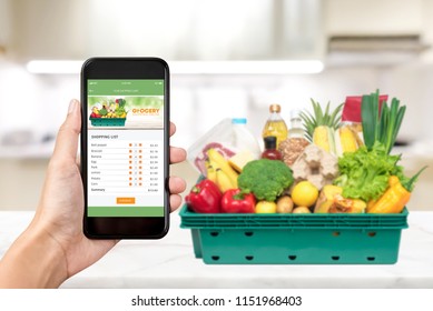 Grocery online shopping application on smartphone screen with food at home in background