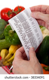 A Grocery Receipt Over A Bag Of Vegetables