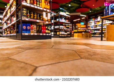 Lebensmittelgeschäft. Alkoholschnitt. Im Einkaufszentrum. Geh einkaufen. Produktauswahl. Tägliche Sorgen. Die Zeit des Konsums. Konzentriere dich auf den Boden. Nahaufnahme von der Ebene der Bodenfliesen.
