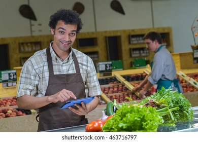 Grocery Store Employee Reading Inventory List On Digital Tablet, France