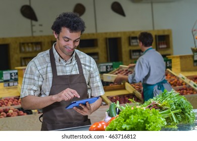 Grocery Store Employee Reading Inventory List On Digital Tablet, France