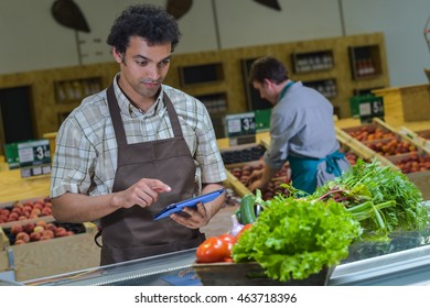 Grocery Store Employee Reading Inventory List On Digital Tablet, France