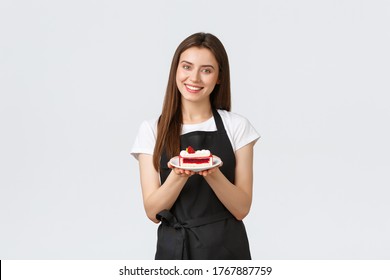 Grocery store employees, small business and coffee shops concept. Friendly smiling cafe worker serving dessert on plate. Cute barista in black apron give guest new delicious cake from menu - Powered by Shutterstock