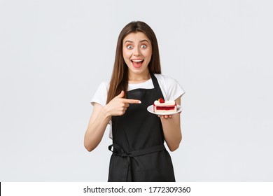 Grocery store employees, small business and coffee shops concept. Friendly smiling barista showing new dessert on menu, pointing at delicious dessert, inviting guests to cafe - Powered by Shutterstock