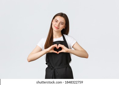 Grocery store employees, small business and coffee shops concept. Lovely friendly-looking barista inviting have taste of new drinks in cafe, showing heart sign to express love for visitors