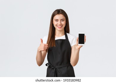 Grocery Store Employees, Small Business And Coffee Shops Concept. Satisfied Cute Friendly-looking Barista Or Waitress Show Thumbs-up And Mobile Phone Sreen, Recommend Download Application