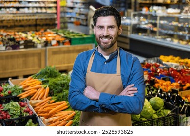 Grocery store worker in apron confidently poses in produce section, highlighting fresh vegetables and fruits. Environment reflects friendly atmosphere and dedication to quality produce. - Powered by Shutterstock