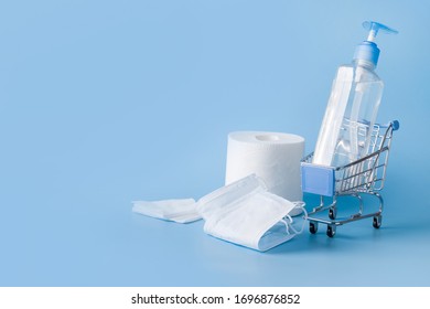 Grocery Trolley With Disinfecting Gel, Wet Wipes, Protective Mask. Concept Of Dangers Of Shopping During The Coronavirus Pandemic COVID-19. Scarce Goods And Basic Remedies.