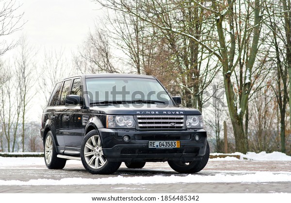 Grodno, Belarus,
December 2012: Land Rover Range Rover Sport V8 Supercharged. Three
quarter view of black SUV over out of focus winter park background
with copy space.