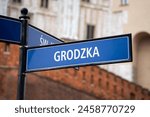 Grodzka street name sign in the Old Town district of Krakow, Poland. Information direction signage plate on a signpost in Kraków. One of the oldest streets of Cracow.