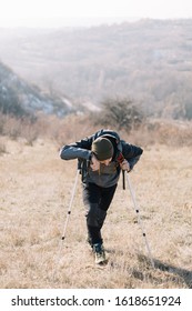 Groggy Man Resting On Hills Backing Up With Poles