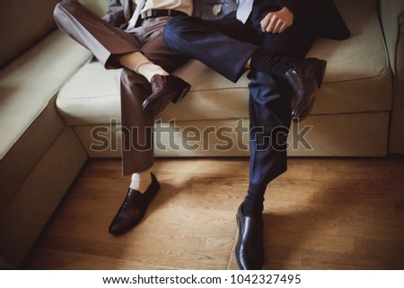 The groom and best man are sitting in anticipation of the ceremony throwing his leg on his leg