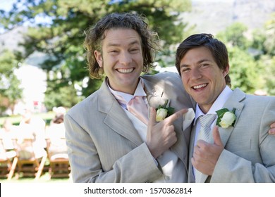 Groom And Best Man In Wedding Suits Outdoors, Laughing