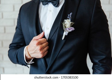 The Groom In A Black Wedding Suit, A Tuxedo In A White Shirt And A Buttonhole