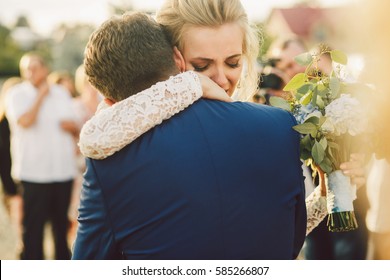 Groom In Blue Suit Hugs Crying Blonde Bride