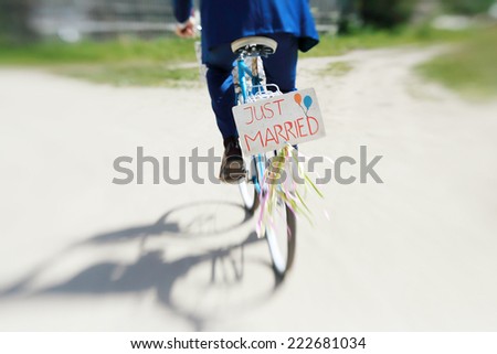 The groom in a blue suit riding a bicycle wedding