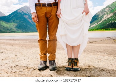 Groom And Bride In Hiking Shoes. Mountain Background. Unique Wedding Fashion. Ready For The Adventure Couple