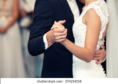 the groom and the bride hold each other by hands