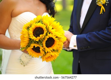 Groom And Bride Holding Sunflower Wedding Bouquet