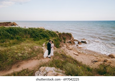 The groom and bride on a walk outdoors near the water - Shutterstock ID 697042225