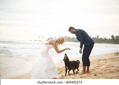 groom and bride playing on the beach on a tropical island