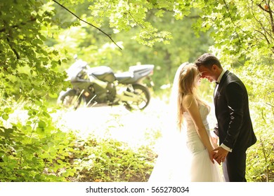 groom and bride posing in the forest