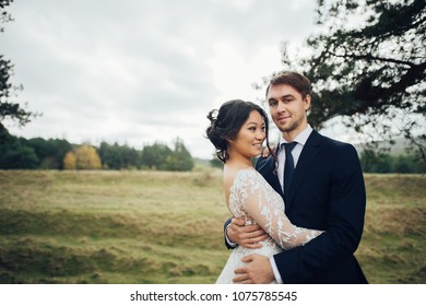 Groom with bride posing outdoor in wedding day