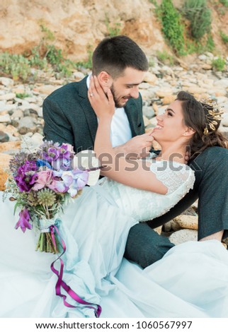 Groom and bride in wedding dress at the seaside