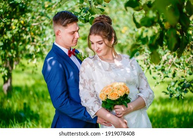 Groom In A Bright Blue Suit And Red Bow Tie On A Walk In A Summer Park