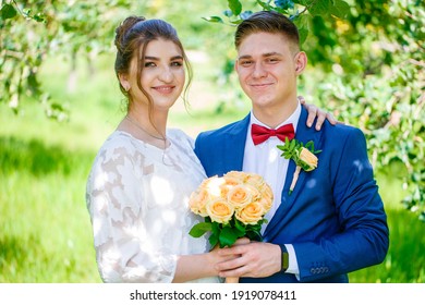 Groom In A Bright Blue Suit And Red Bow Tie On A Walk In A Summer Park