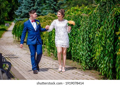 Groom In A Bright Blue Suit And Red Bow Tie On A Walk In A Summer Park