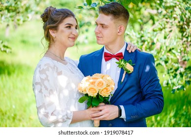 Groom In A Bright Blue Suit And Red Bow Tie On A Walk In A Summer Park