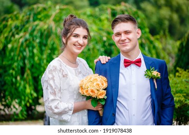 Groom In A Bright Blue Suit And Red Bow Tie On A Walk In A Summer Park